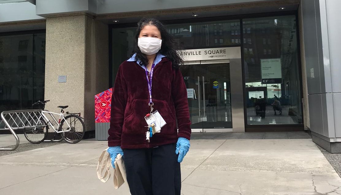Cleaning worker poses in front of building