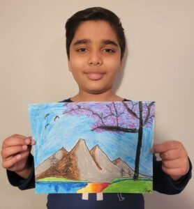 Child holding up picture of mountains