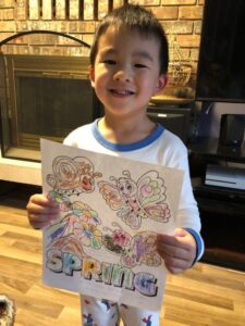 Child holding up painting of butterflies