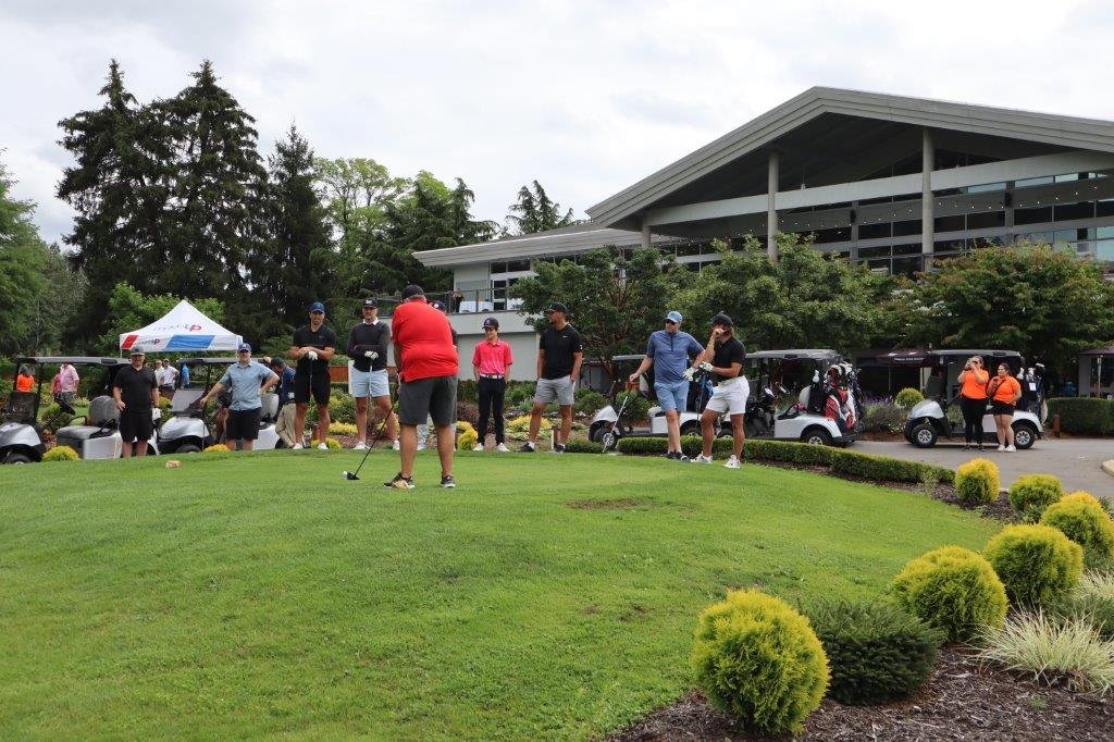 Golfers and volunteers around the green at a golf course