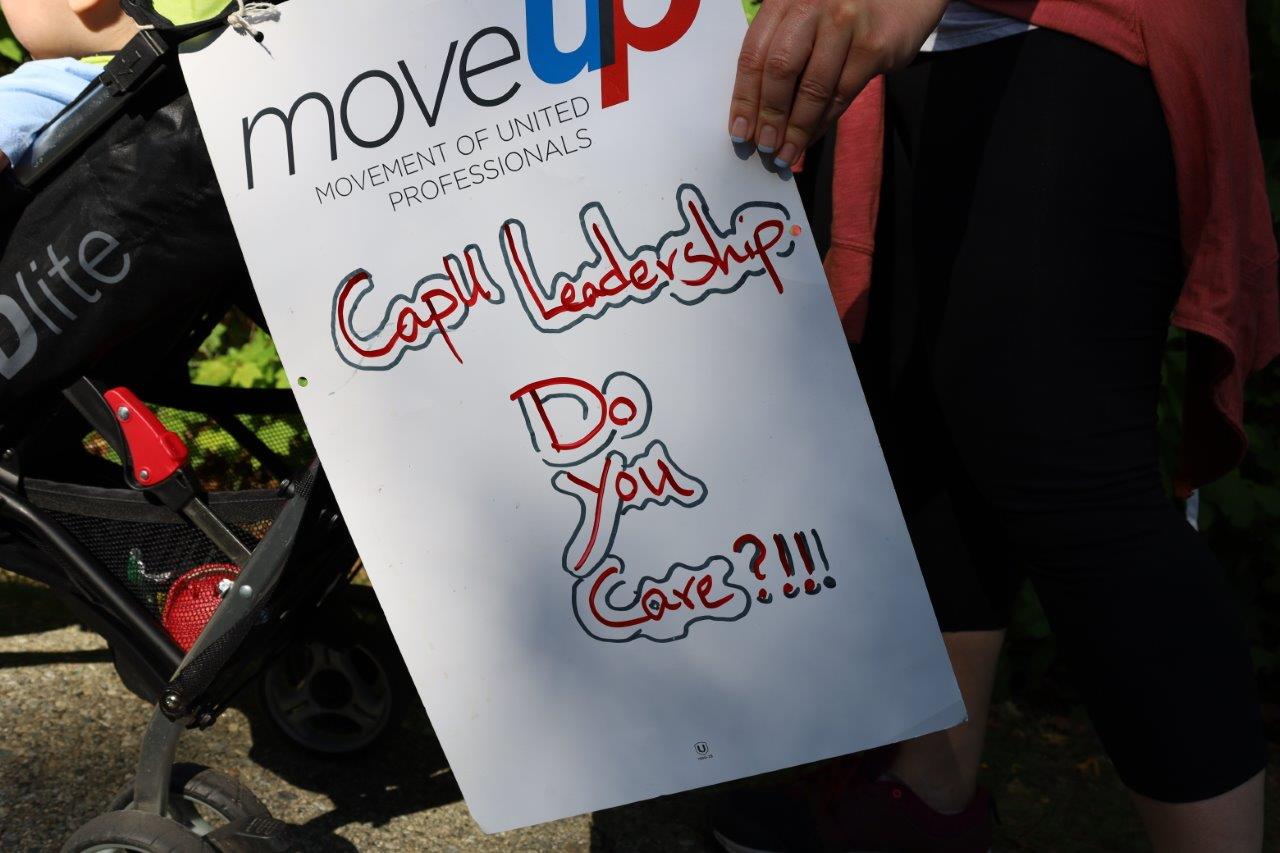 Picket sign with MoveUP logo and the text: 