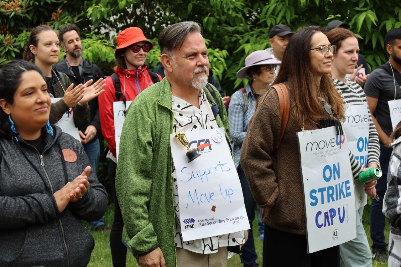 MoveUP members and CFA members stand side by side on the Capilano University picket line wearing picket signs