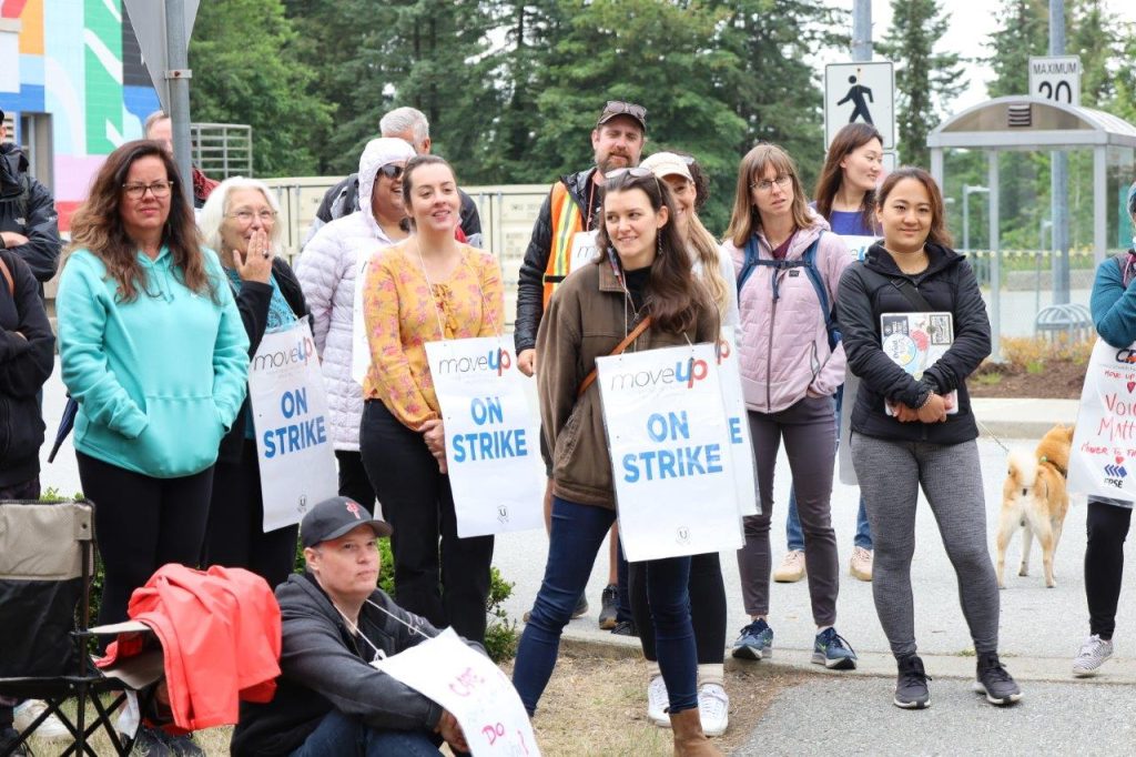 MoveUP members wearing picket signs at the Capilano University picket line