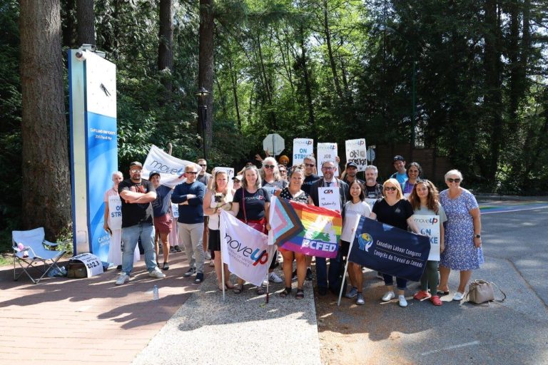 MoveUP members pose on the picket line at the main entrance of CapU with MoveUP leadership, CLC President Bea Bruske, and BCFED President Sussanne Skidmore