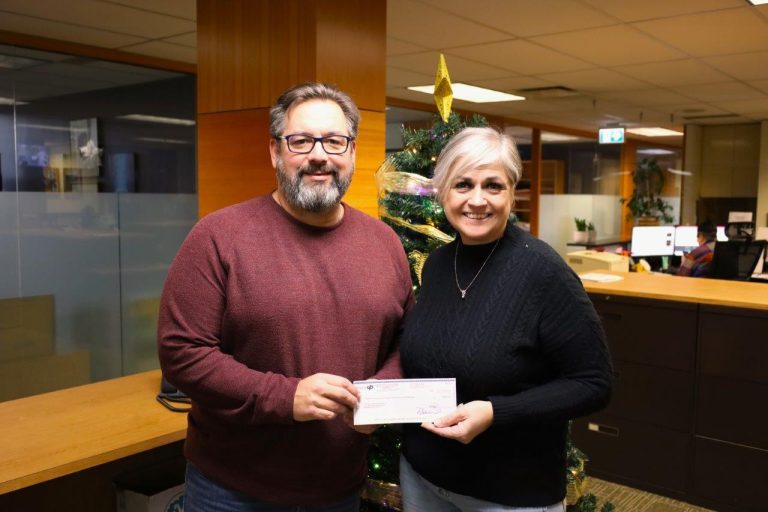 Scott Lunny and Annette Toth hold up a cheque