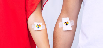 Arms with bandage with intersex pride flag in shape of heart on each bandage