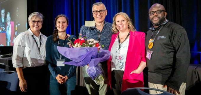 Zoran Stjepanovic (centre), recipient of the Peter Corren Award, poses for a photo after accepting the award with several individuals from MoveUP