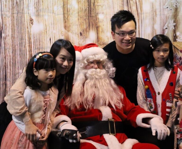 Family of four posing with Santa Claus in middle