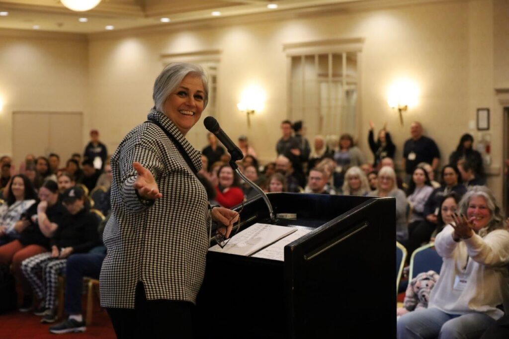 Job stewards clapping behind Annette at podium