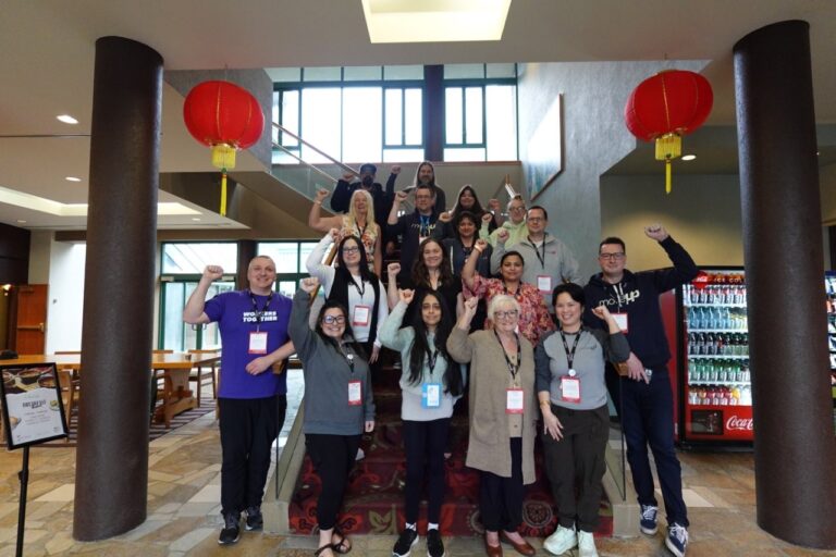 Job stewards pose for a group photo with their fists raised