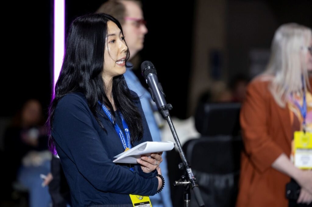 MoveUP Secretary-Treasurer Brenda Chu speaking at a microphone at the CLC Convention