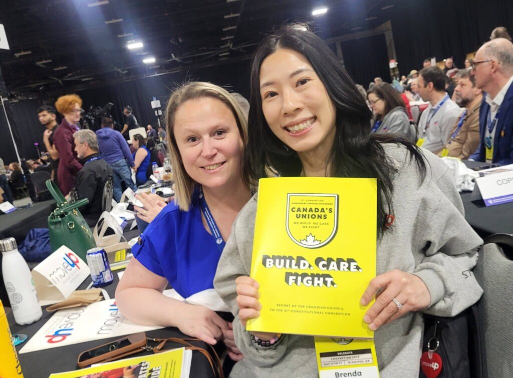 MoveUP VP Christy Slusarenko and Secretary-Treasurer Brenda Chu pose with a CLC Convention booklet at the 2026 CLC Convention.