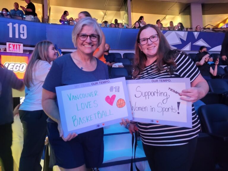 MoveUP President Annette Toth and MoveUP member sharing signs of support for women's sports